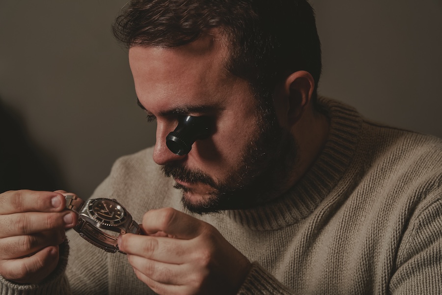 Andrea Piccinini con una lente che ispeziona un orologio vintage